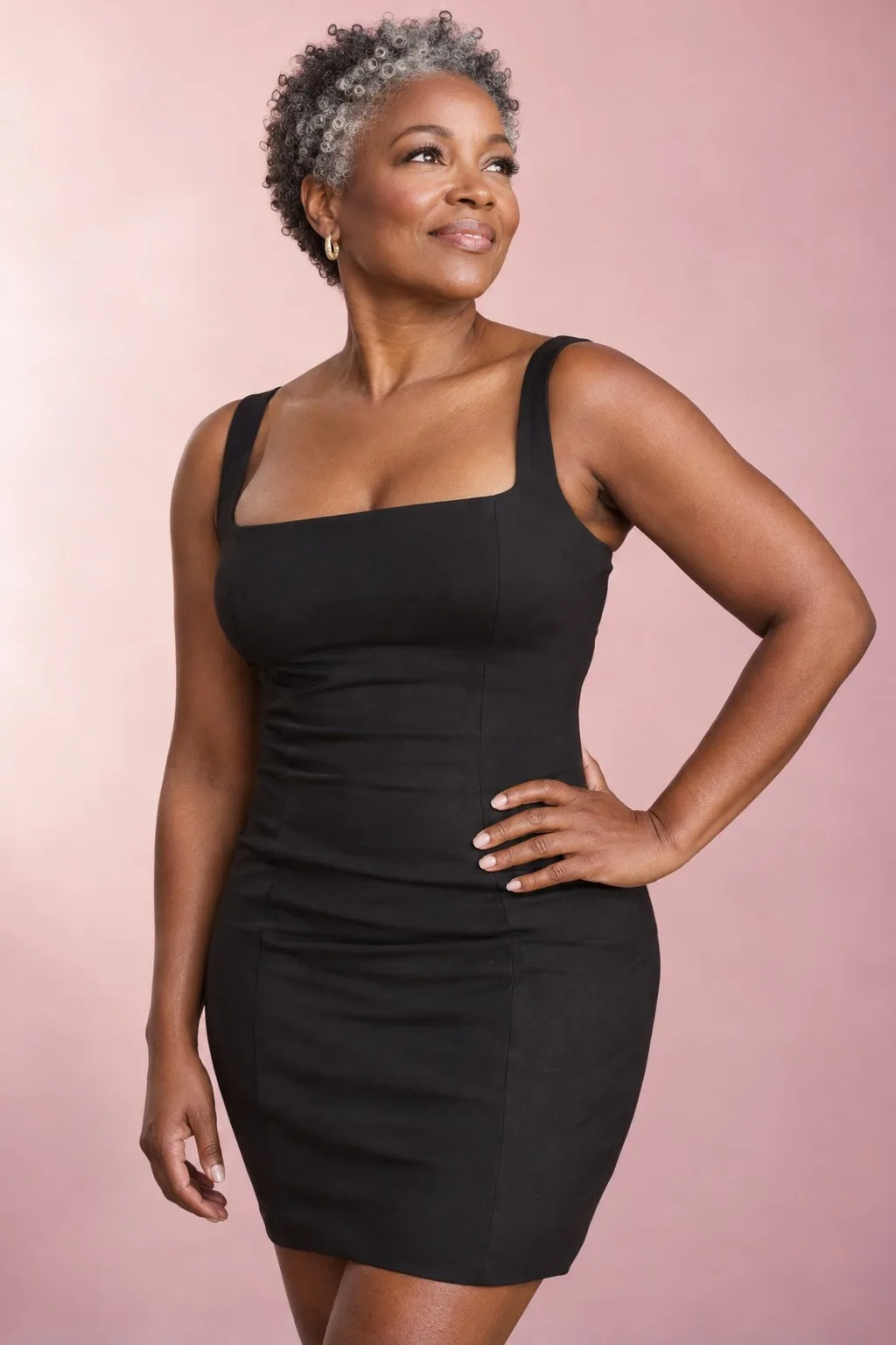 Woman in her fifties in a black dress, smiling confidently